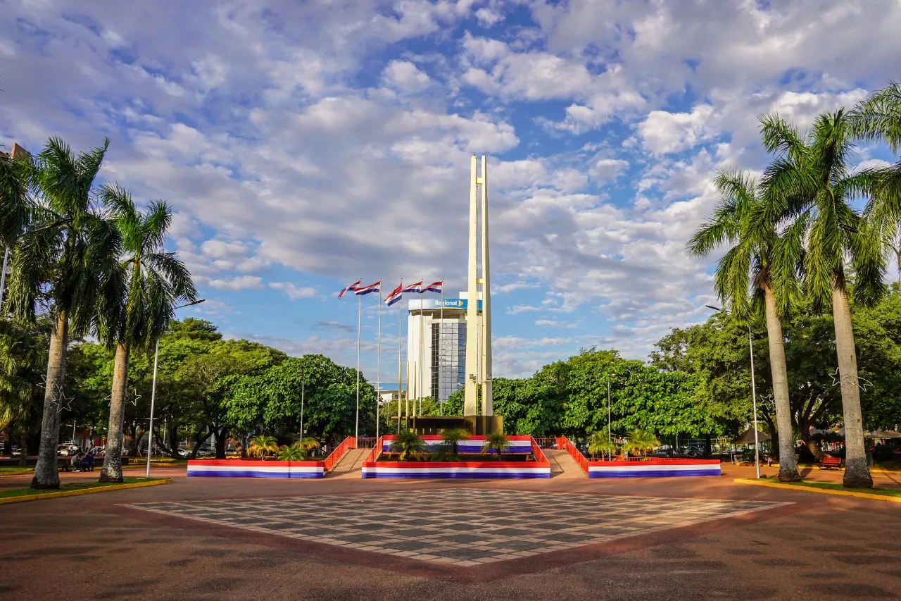 Plaza de Armas de Encarnación · obelisco, palmeras y cielo paraguayo